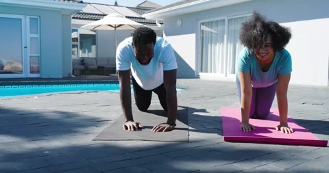 Couple arriving poolside patio unrolling pink and gray mats and holding plank to Stock Footage 338325238