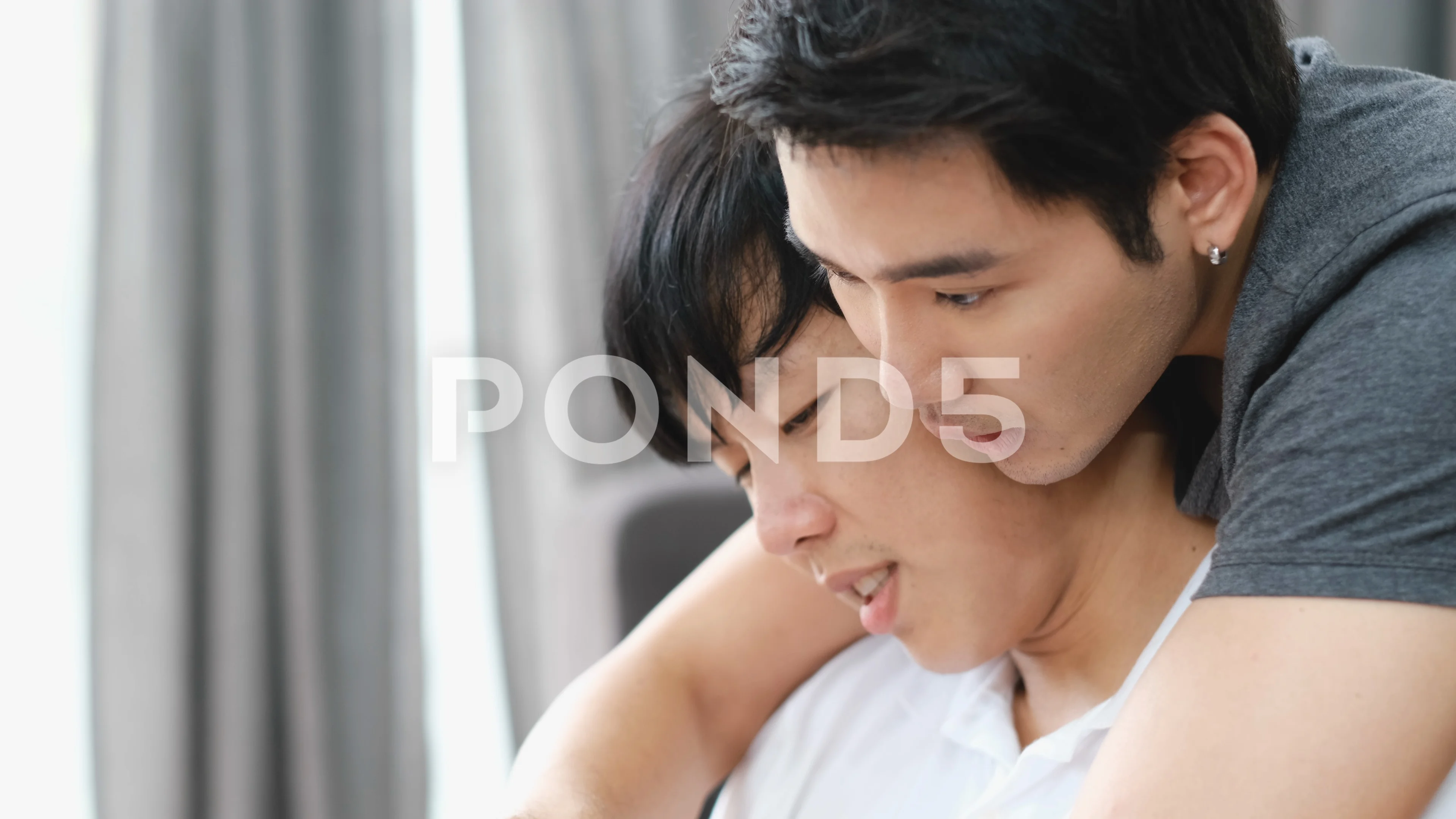 Couple Asian gay enjoy to have activity together in living room and happy.