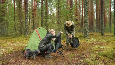 The couple assembles foldable outdoor chairs, inserting and stretching the seat Stockbeeldmateriaal 318659201