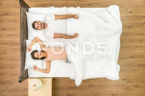 The couple awake on the bed. View from above Stock Photos