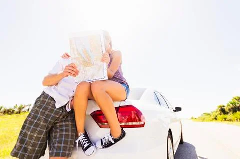 Couple at back of car looking at map Fotos Stock