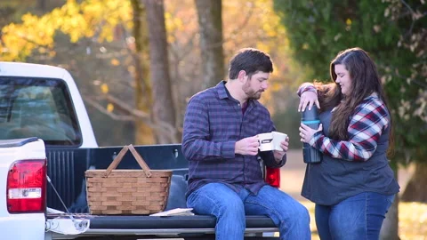 Couple at the back of a pick-up planning a trip while enjoying the fall colors Stock Footage