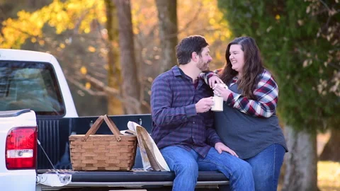 Couple at the back of a pick-up planning a trip while enjoying the fall colors 库存影片 143430239