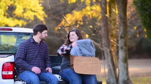 Couple at the back of a pick-up planning a trip while enjoying the fall colors 库存影片 143430547