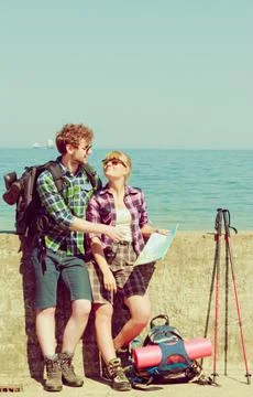 Couple backpacker with map by seaside Stock Photos