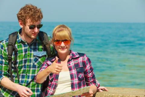 Couple backpacker with map by seaside Stock Photos