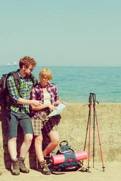 Couple backpacker with map by seaside Fotos Stock