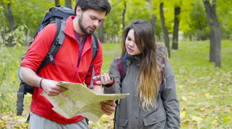 Couple of backpackers looking at the  paper map in the autumn forest Stock Footage 59797559