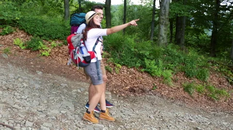 Couple of backpackers pointing and going down the hill Stock Footage 52789782
