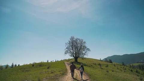 Couple with backpacks climbs the hill Stock Footage 76249752