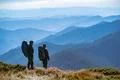The couple with backpacks standing on the mountain with a beautiful view Photo