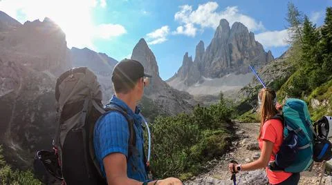 A couple with backpacks taking a selfie while hiking in Italian Dolomites. Stock Photos