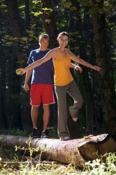 Couple balancing on tree trunk Stock Photos