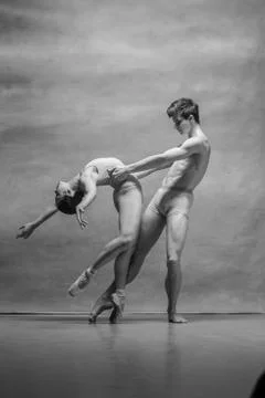 Couple of ballet dancers posing over gray background Fotos Stock