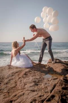 Couple with balloons on the beach. Stock Photos