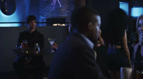 A couple at a bar talk to each other as they cheers Stock Footage 34005448