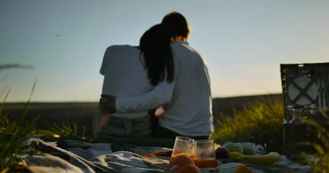 Couple with basket of fruit and drinks relaxes at weekend. Stock Footage 153879527