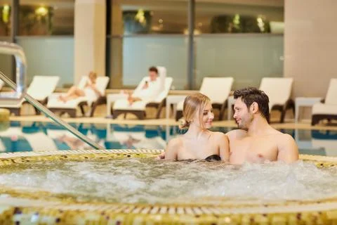 Couple in bathing suits in the pool resting spa center Stock Photos