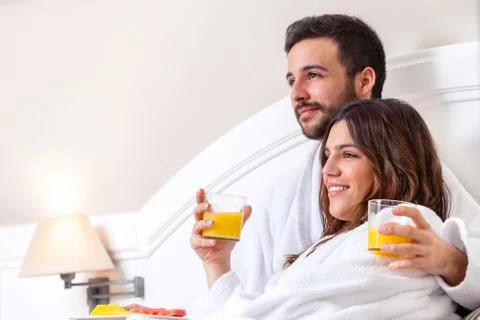 Couple in bathrobe drinking orange juice. Stock Photos