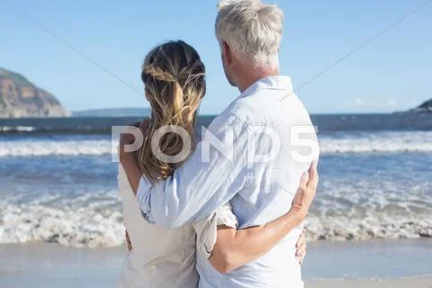 Couple on the beach looking out to sea Stock Photos