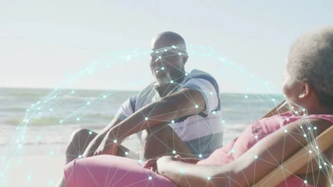 Couple on beach, man leaning and smiling then waving, network nodes highlighting Stock Footage 333648136