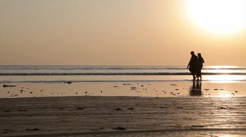 Couple at the beach in silhouette Видео 67982059