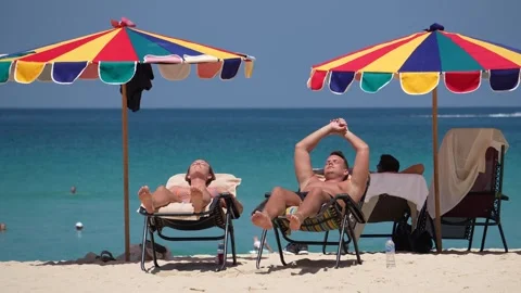 A couple on the beach sunbathing during their vacation in Thailand Stock Footage 275345243