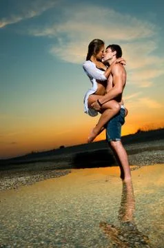 Couple on the beach at sunset Stock Photos