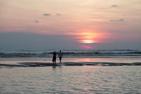 Couple on beach in sunset. Stock Photos