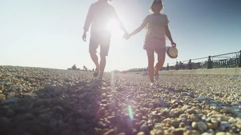 Couple on a beach walk towards camera holding hands Vidéo 52154696