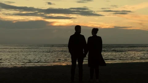 Couple at the beach watching the sunset - 4K 库存影片 136470484