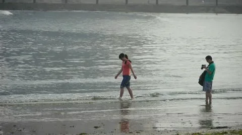 Couple at beach.Photographer taking pictures.Female model to pose.tide,tidal. Stock Footage