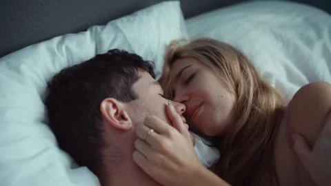 Couple in bed gently stroking each other . white sheets, delicate tones Stock Footage 235495865