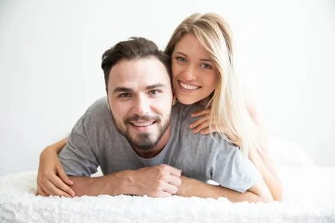 A couple in bed look at camera and smile with happy lover Stock Photos