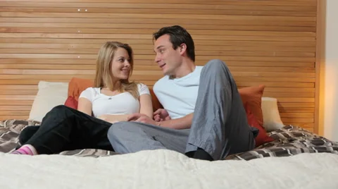 Couple in bed talking on cell phone Video stock 62281415