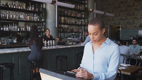 Couple Being Greeted By Maitre D Using Digital Tablet As They Arrive At Stock Footage 129934129