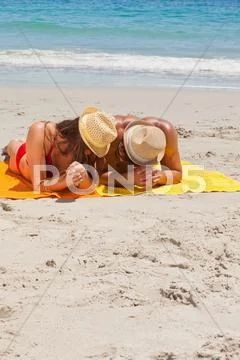 Couple being tanning on the beach Stock Photos