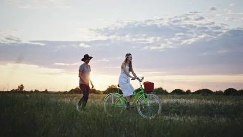 Couple with bicycle having fun in field Video stock 219954163