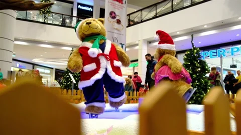 Couple of big artificial bears dressed in Santa Claus suites are skating. Stock Footage 138320490