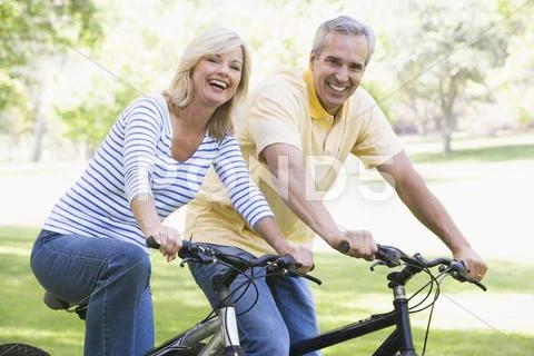 Couple on bikes outdoors smiling Stock-Fotos