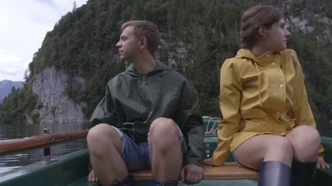 Couple on the boat is looking around in the middle of the mountain lake Stock Footage 83625865