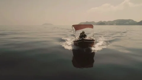 Couple on a boat sailing in calm water in the middle of the ocean Stock Footage