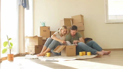 Couple with book sitting on bed while moving into new home Stock Footage 98795223
