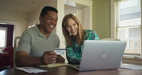 Couple book trip or make purchase online with credit card using laptop computer Stock Footage 116893276