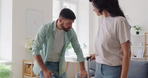Couple breakup and relationship issues, begging man by suitcases of woman Stock Footage 319418139