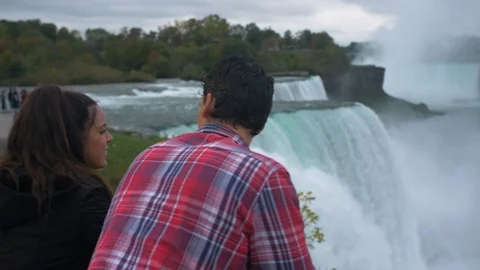 Couple on Bridge Looking at Niagara Falls, Tourists Viewfinder Stock Footage 102444736