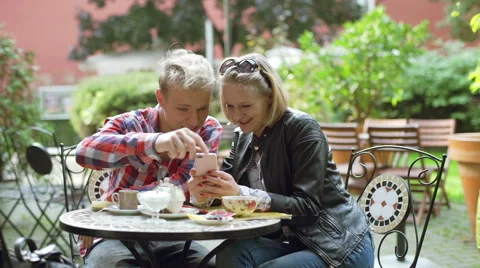 Couple browsing internet on smartphone and smiling to the camera Stock-Footage 56247637