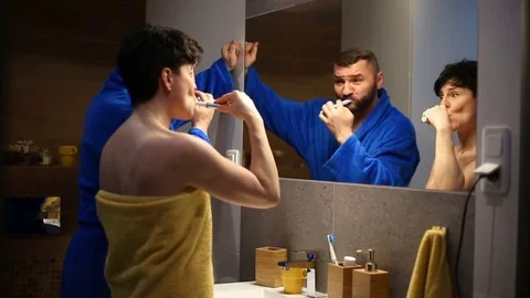 Couple brushing their teeth in the bathroom in the morning Stock Footage 73753599