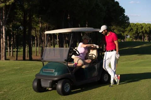 Couple in buggy on golf course Fotos Stock