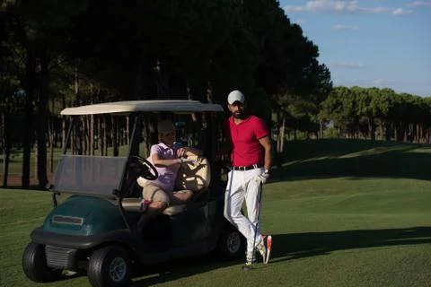 Couple in buggy on golf course Fotos Stock